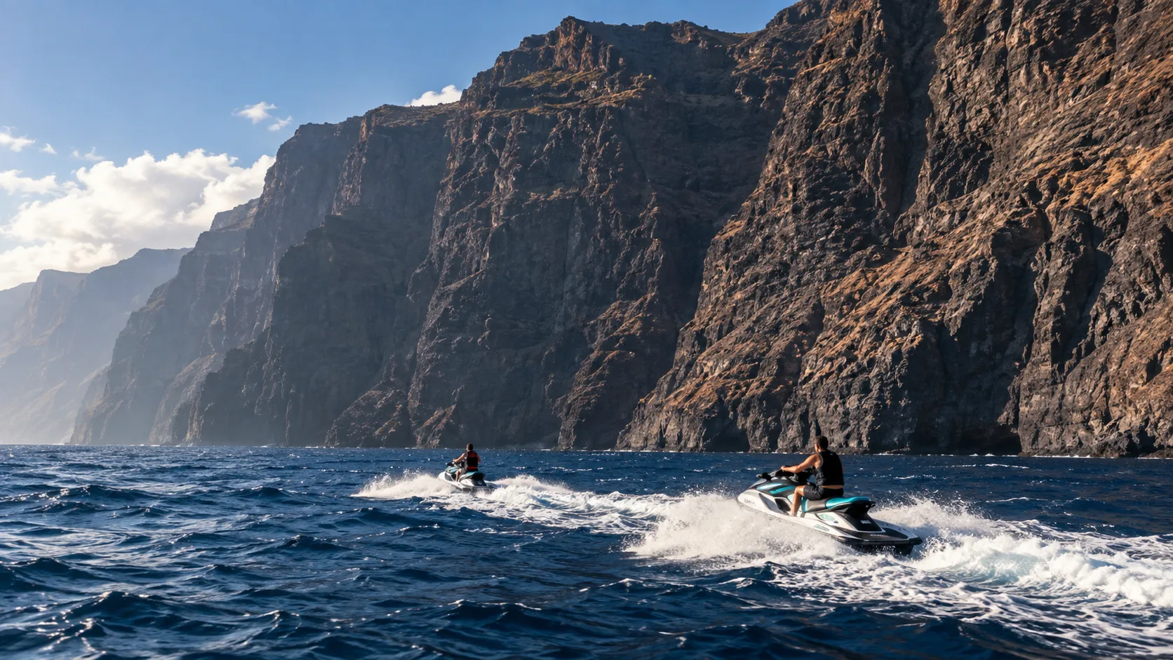 Jet skis navigating beside the basalt cliffs of Los Gigantes
